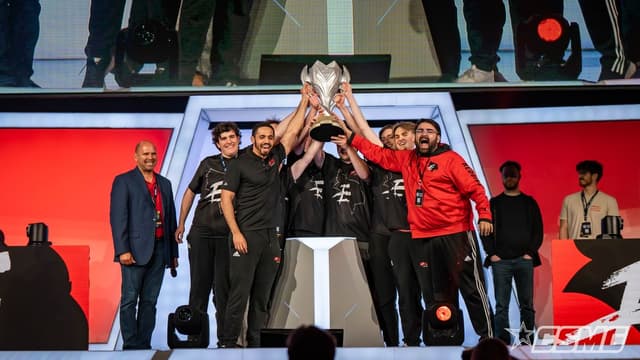 Winning team lifting the championship trophy on stage