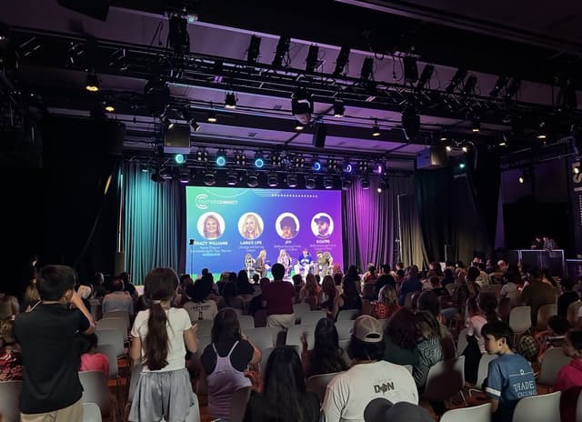 Panel discussion on stage in front of a packed audience